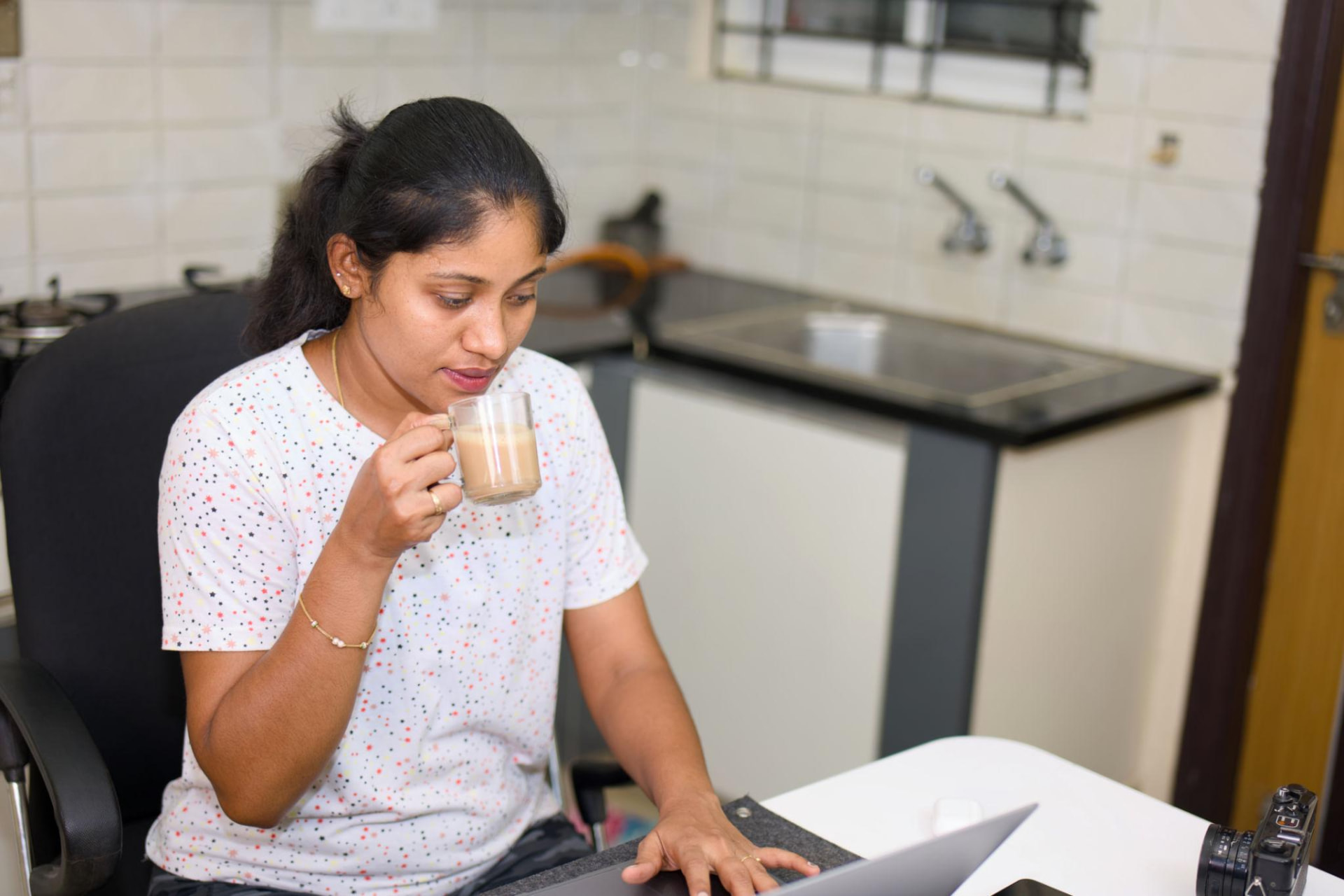 Sipping a quick glass of instant coffee at the work desk between tasks
